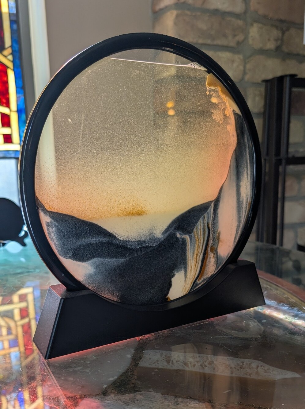 10 inch Moving Sand Art Picture It is round with a black stand.The sand art